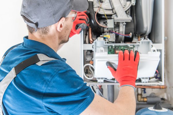 Heating Central Gas Furnace Issue. Technician Trying To Fix the Problem with the Residential Heating Equipment.