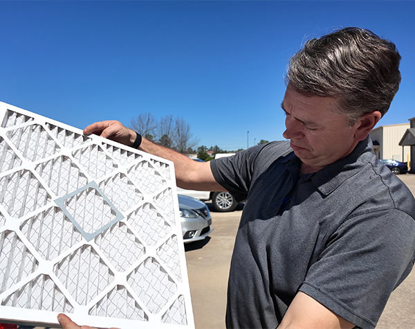 service technician checking furnace filter